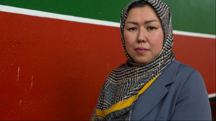 Sabera Mulher afegã de lenço em parede colorida