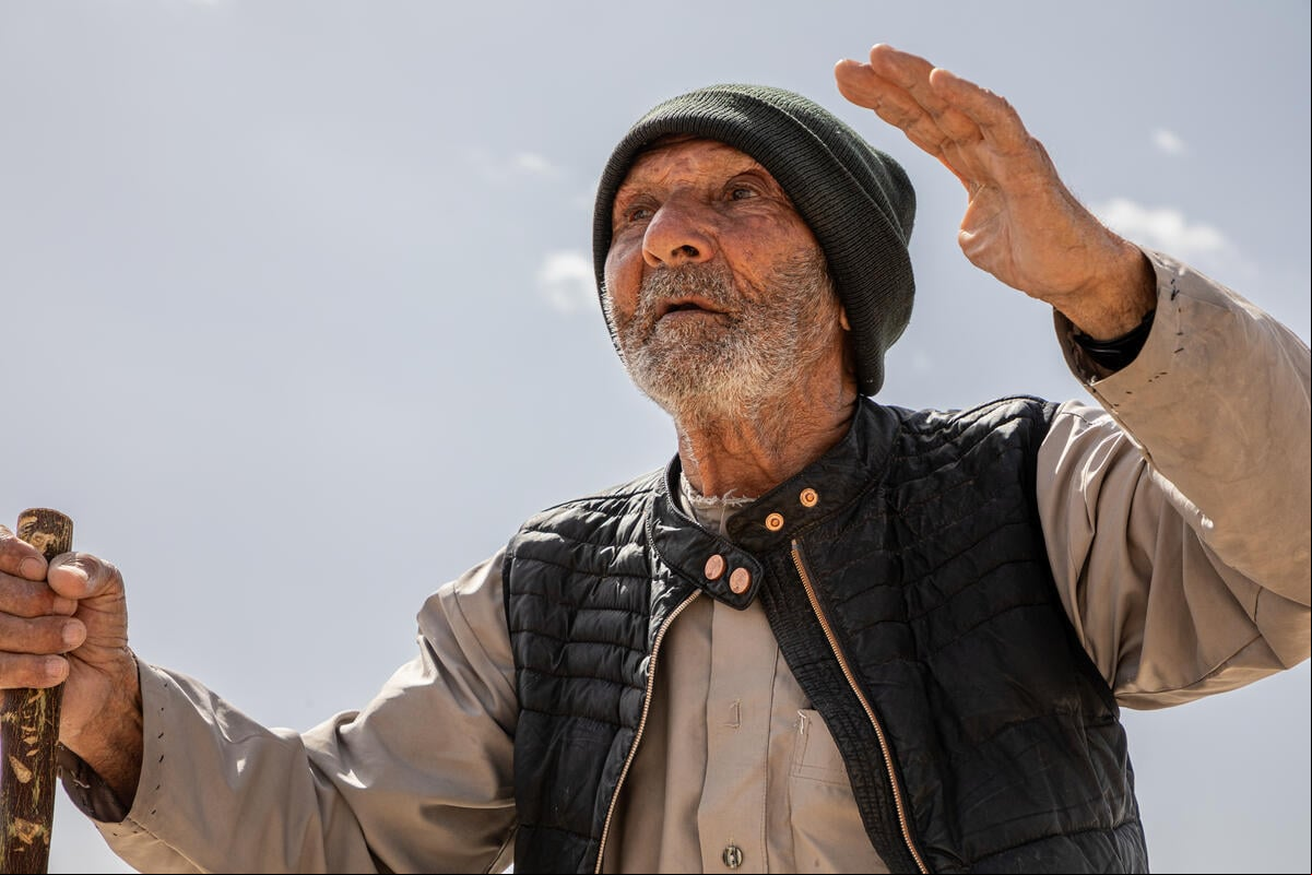 Jassim, retornado sirio de 103 años, junto a los restos de su antigua casa en la zona rural de Al-Qusayr, en la gobernación de Homs.
