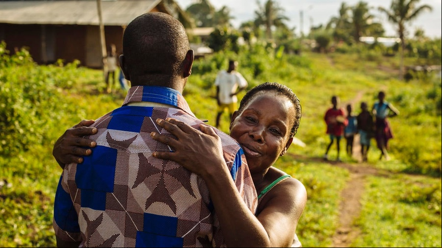 Un refugiado de Côte d'Ivoire recibe un abrazo de su tía al volver a casa