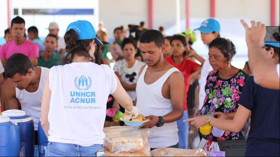 Una trabajadora de ACNUR ayuda a familias venezolanas que se han quedado durmiendo a la intemperie en la plaza Simón Bolivar en Boa Vista, Brasil, a instalarse en el albergue Jardim Floresta. Una trabajadora de ACNUR ayuda a familias venezolanas que se han quedado durmiendo a la intemperie en la plaza Simón Bolivar en Boa Vista, Brasil, a instalarse en el albergue Jardim Floresta.