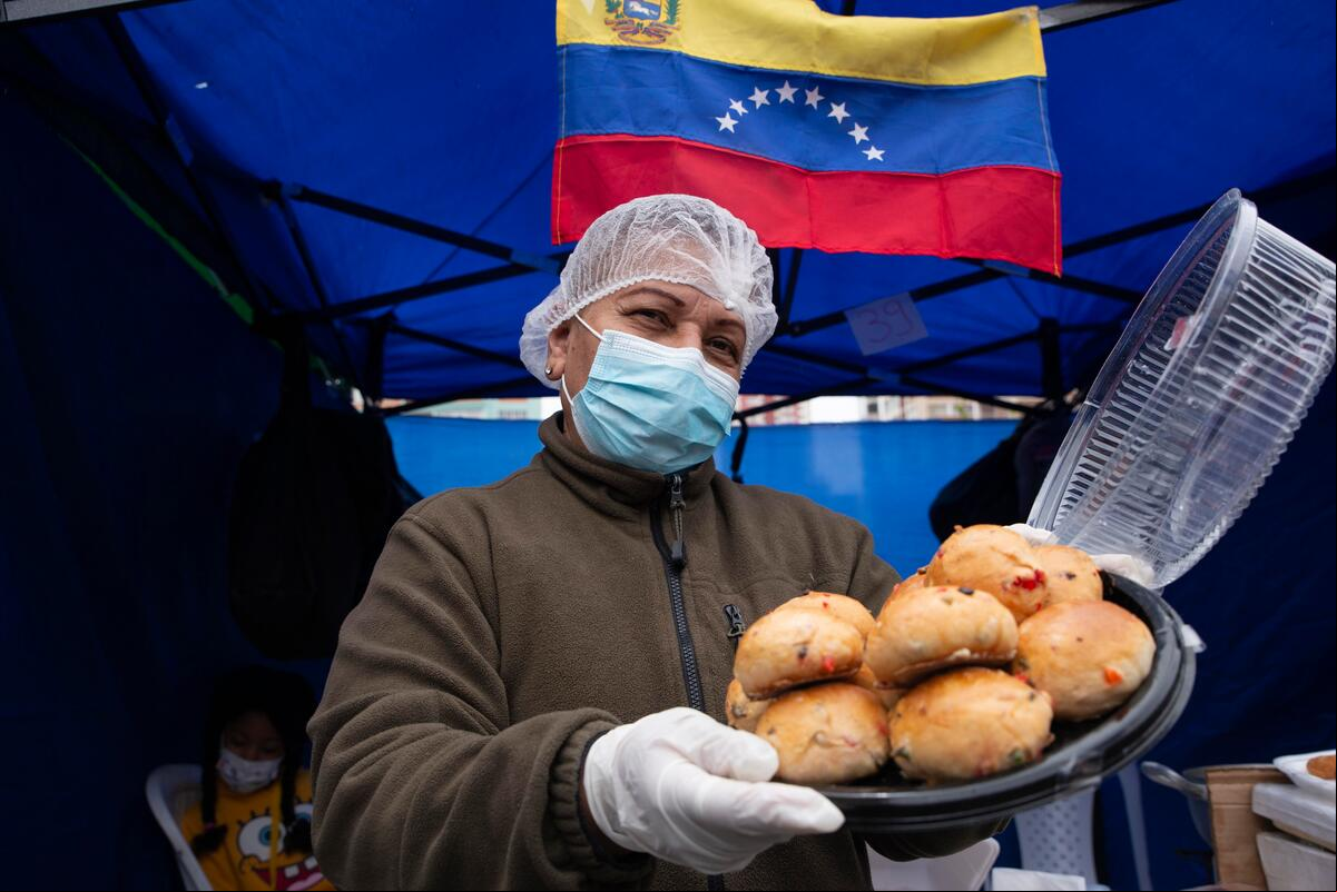 A Venezuelan woman displaced in Boliva shows one of the meals of her gastronomic entrepreneurship at the fair held in the city of La Paz, Bolivia. Bolivia. 40 Refugees and migrants from Venezuela participate in a fair with their enterprises