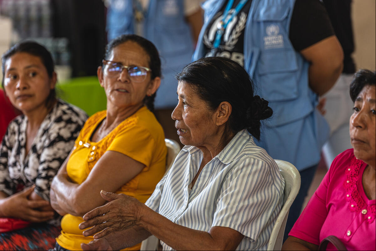 Cuatro mujeres, sentadas una al lado de la otra. Una de ellas está hablando, mientras el resto la escucha.