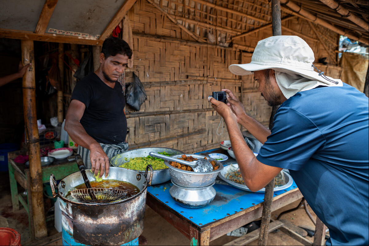 Salim Khan fotografía a un hombre rohingya que prepara comida.