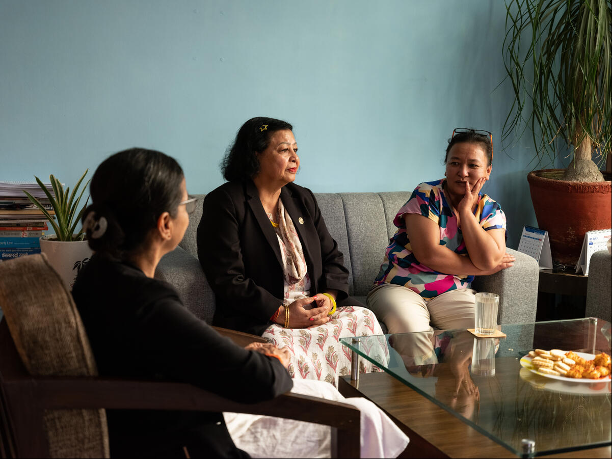 Tres mujeres nepalíes charlan sentadas en una sala