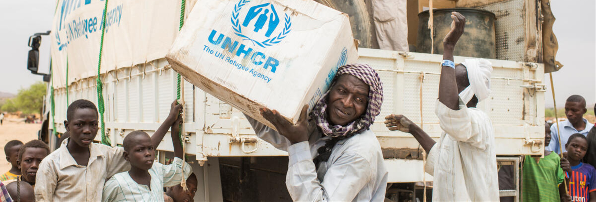 Un grupo de hombres descarga suministros de ACNUR de un camión en Chad