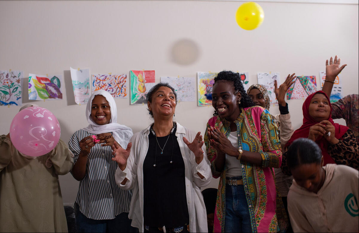 Mujeres aplauden, sonríen y lanzan globos al aire