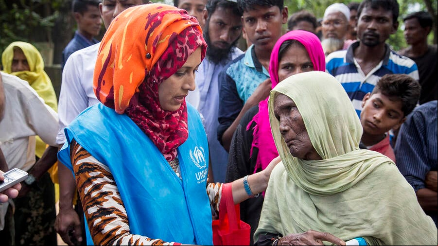 Una mujer mayor recibe una lona de plástico de una trabajadora de ACNUR en el campamento de refugiados de Kutupalong, en Bangladesh.