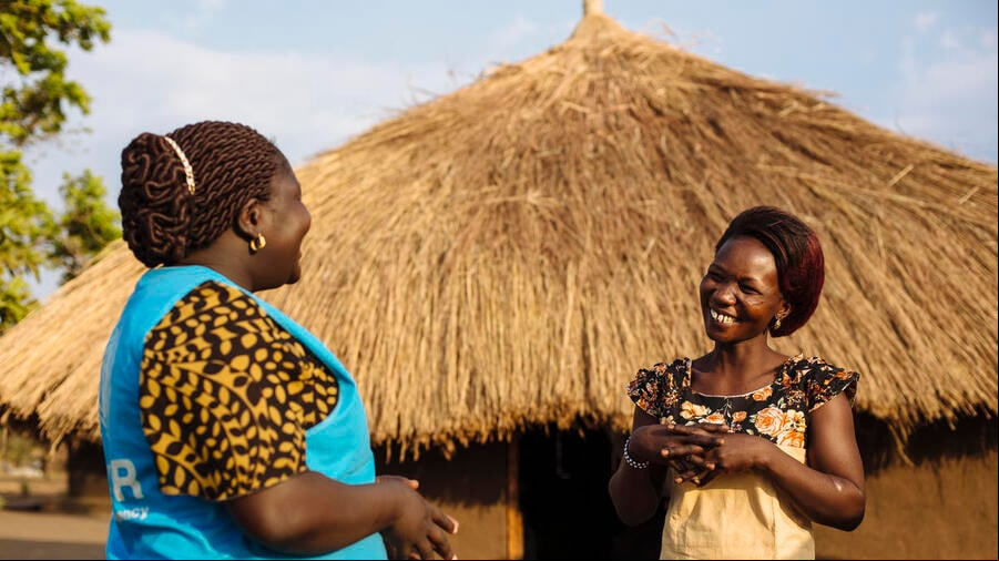 Dos mujeres africanas conversan; una de ellas (la que está a la izquierda) trabaja en ACNUR.