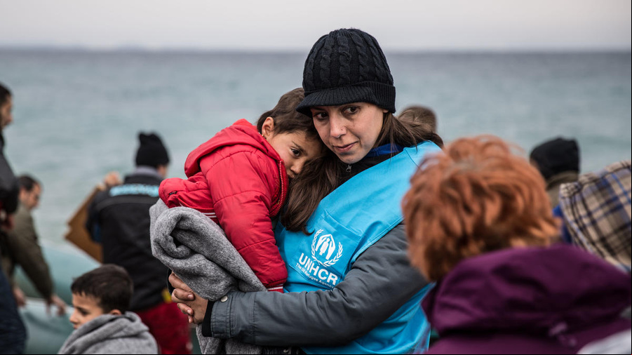 Una trabajadora de ACNUR cubre a un niño refugiado con una manta, luego de que la embarcación en la que él viajaba llegara a Lesvos, una isla griega.