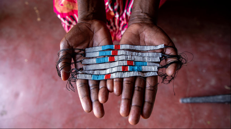 Un par de manos muestran seis pulseras hechas a mano