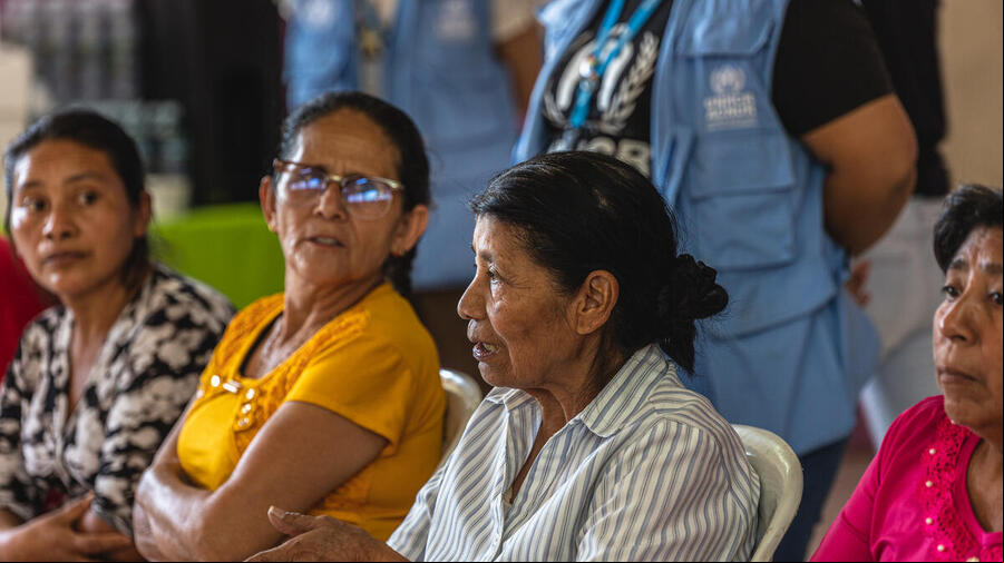 Cuatro mujeres, sentadas una al lado de la otra. Una de ellas está hablando, mientras el resto la escucha.