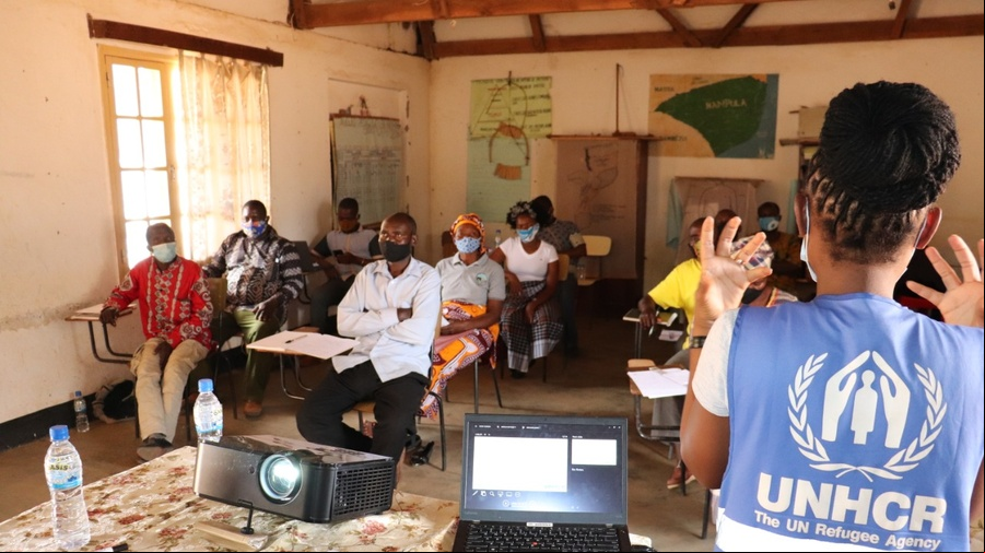 Una trabajadora de ACNUR está dando una capacitación delante de un grupo mixto en Mozambique
